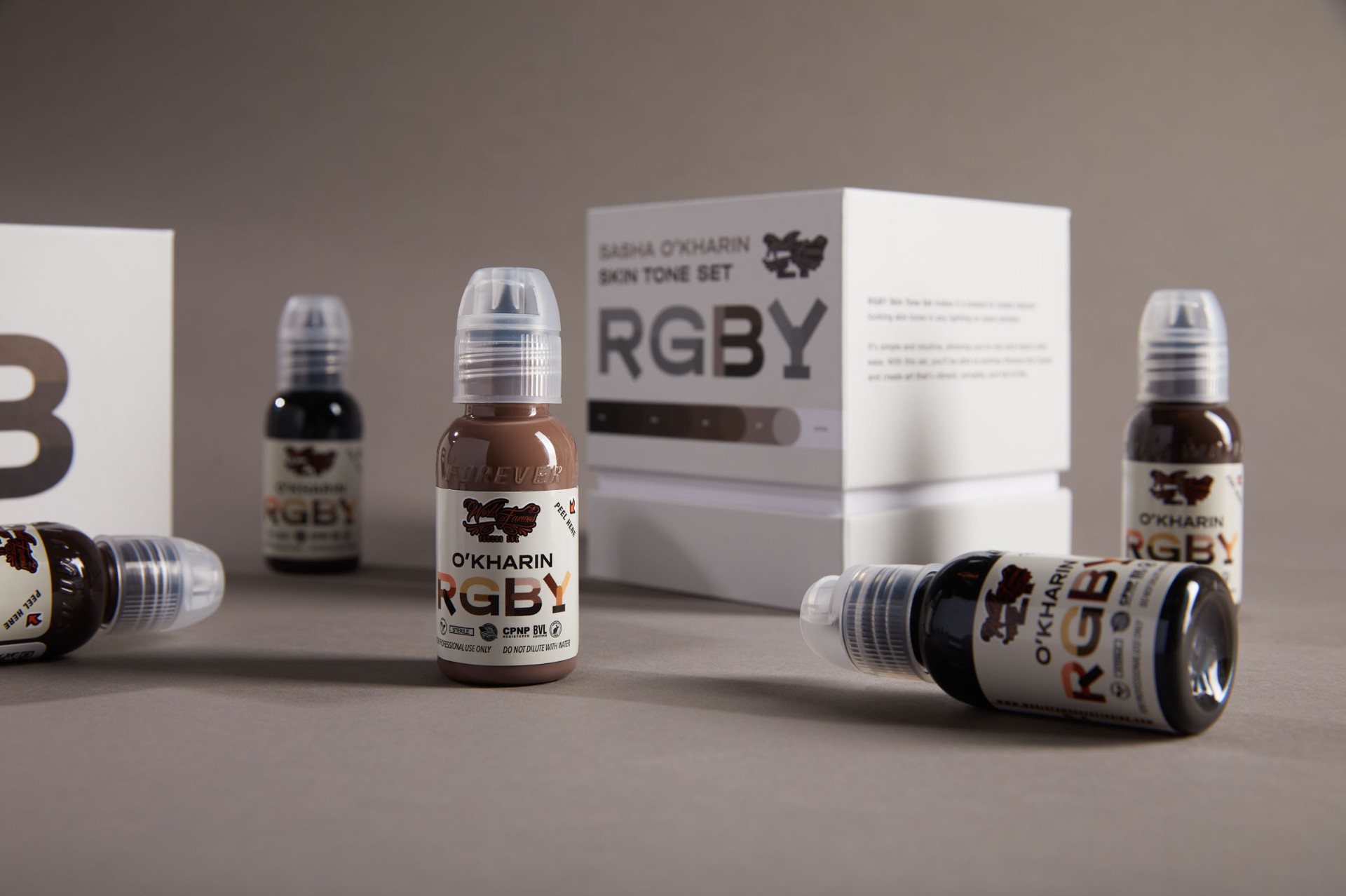 RGBY — B-tone bottle on warm gray backdrop